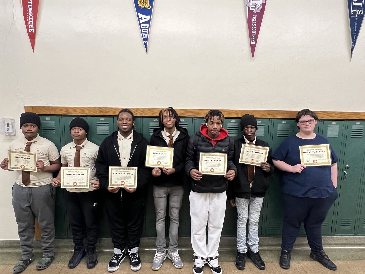  Students holding certificates by lockers
